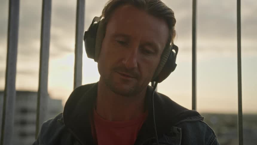 Portrait of a man with headphones making a headshaking gesture of denial