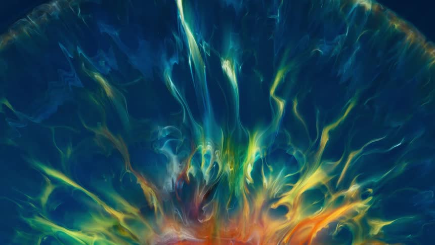 Psychedelic bright colorful liquid ink flowing out in yellow on a dark blue background