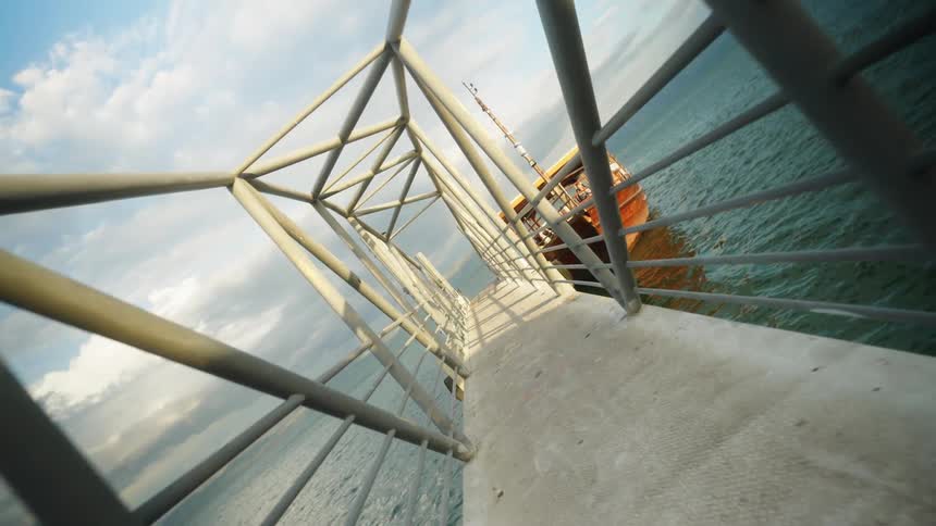 A twisting view of a metal walkway on a pier