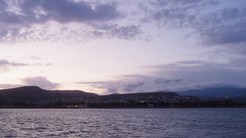 A calm river near a mountain at sunset