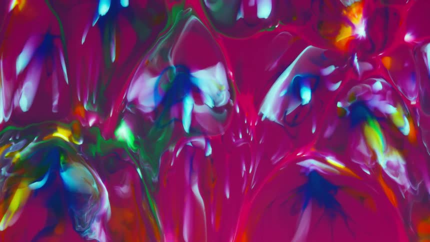 Colorful paint mixed together and slowly dripping down a canvas