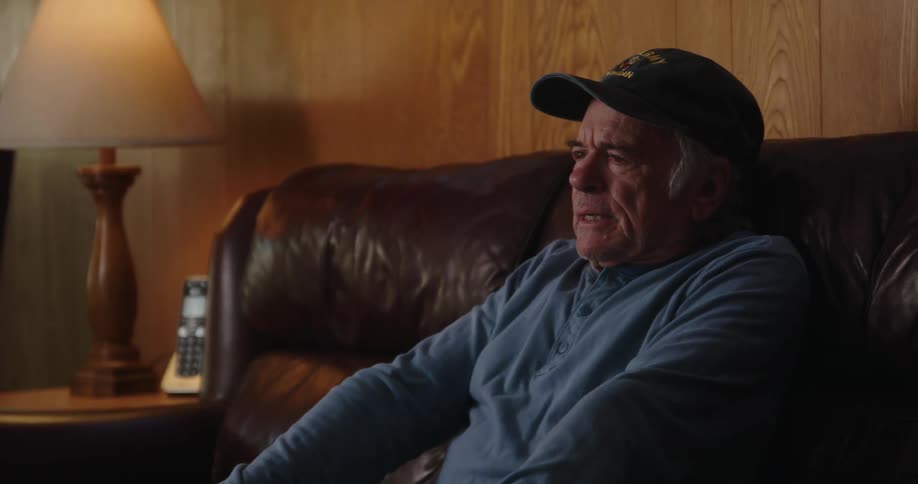 Elderly person watching television and gesturing with hands slightly irritated