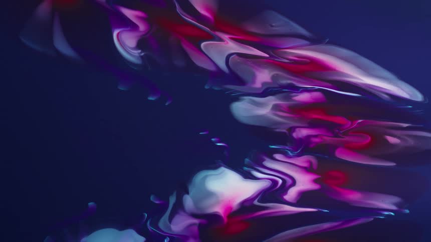 Colorful graphic paint moving slowly and smoothly across a dark blue canvas