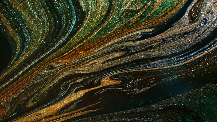 Colorful glitter lines slowly swirling across a black canvas