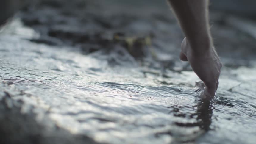 A person puts their hand in the water
