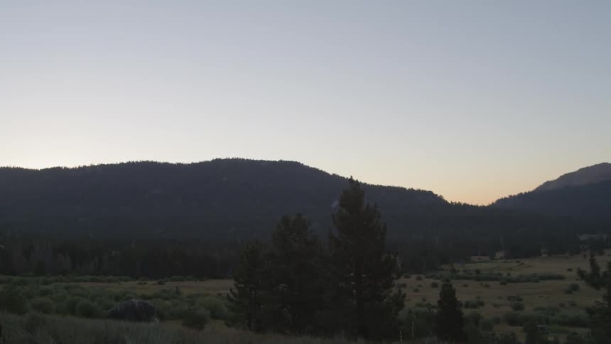 The field leads to a mountain at sunset