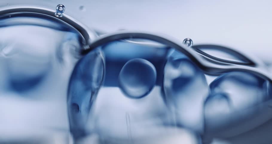 Air bubbles slowly move on a thick blue liquid surface
