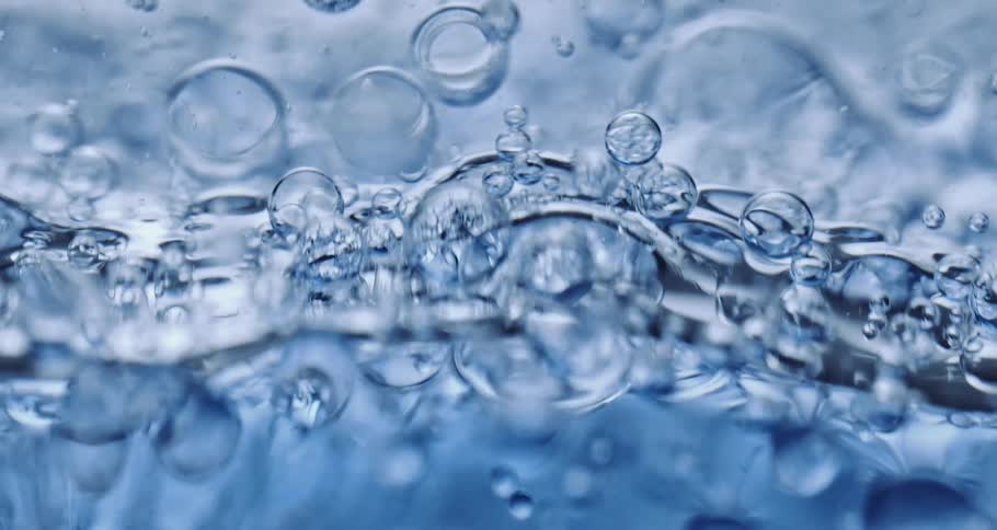 Bright clear blue liquid with bubbles flowing and rising