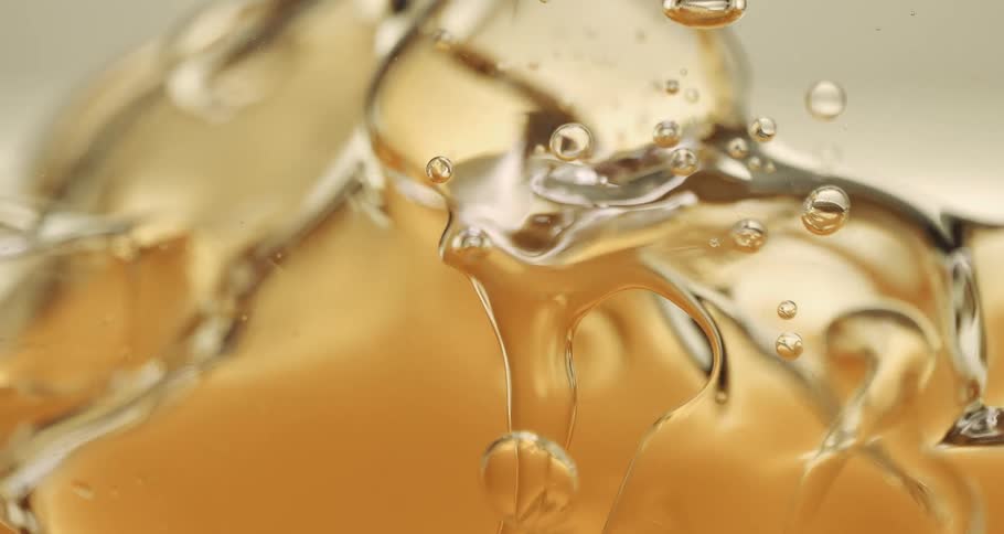 Water droplet falling into a dense liquid creating an abstract impact