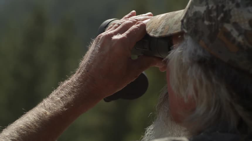 A man is using a pair of binoculars