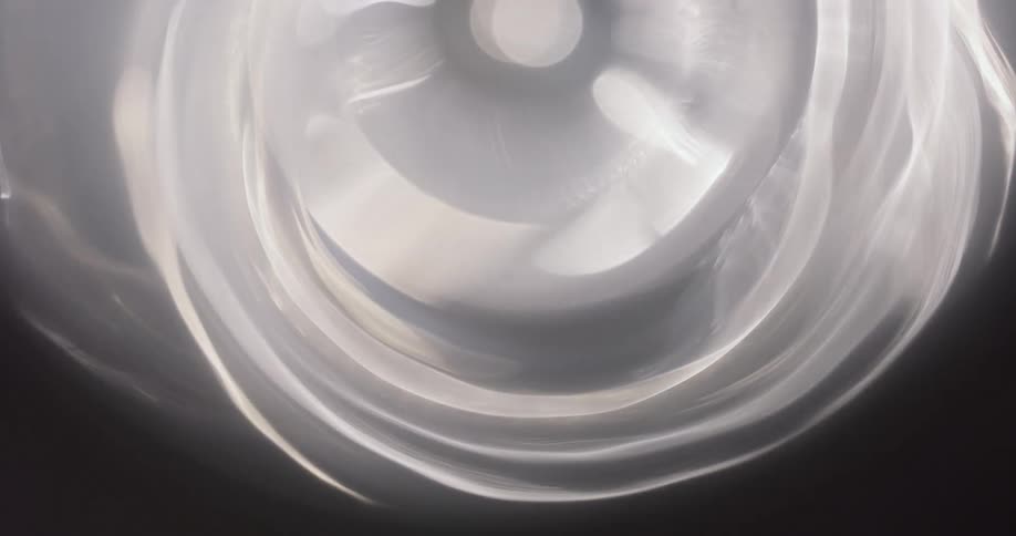 Circular and abstract white light reflection on a black background