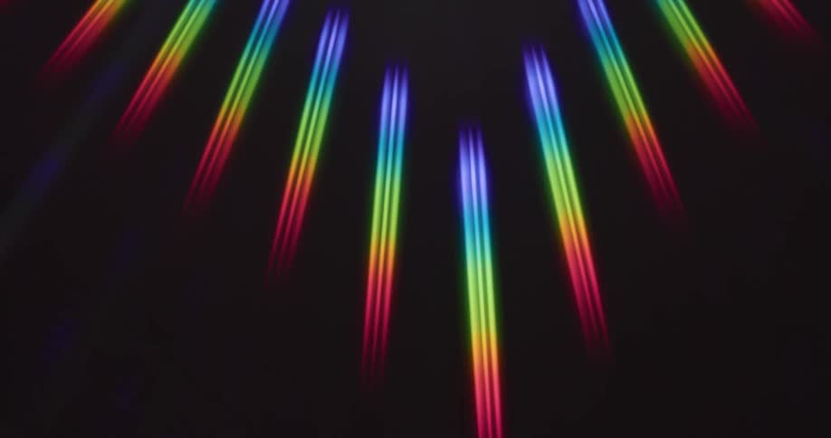 Multiple clusters of rainbow colored parallel beams of light float against a black background
