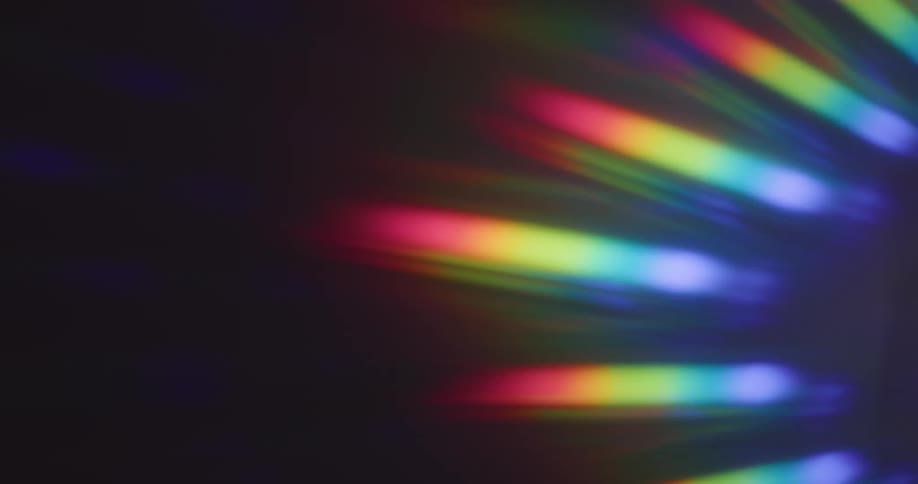 Glowing rainbow colored stripped bars of light shine in the darkness