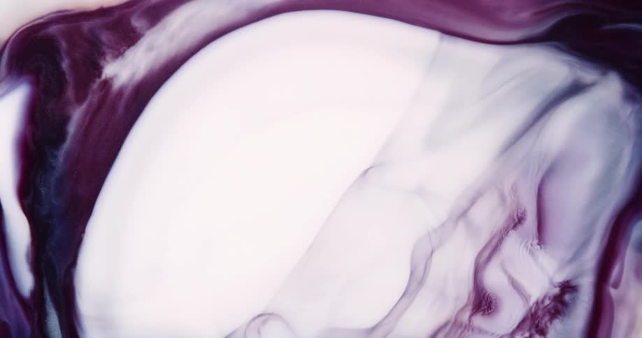 Drop falls on white and purple liquid ink creating a slow expanding wave