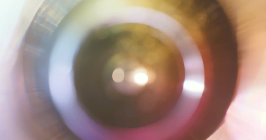 A camera lens close up it is reflects light off the glass while spinning around in circles