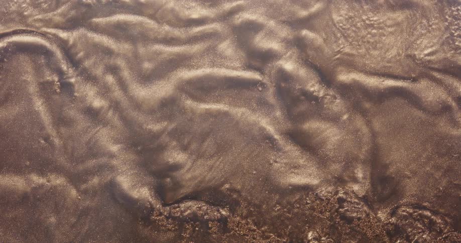 Dense liquid moving on abstract shiny sand