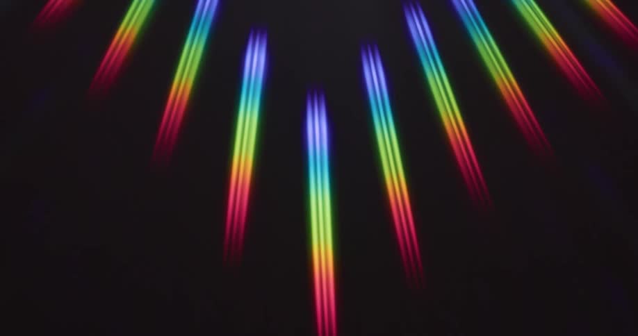Rainbow rays of light reflect on a black surface