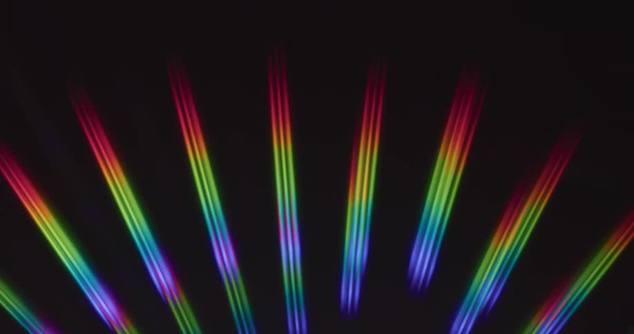 Rainbow rays of light reflect on a black surface
