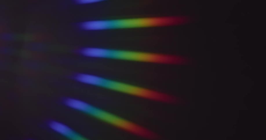Rainbow rays of light spin on a black surface