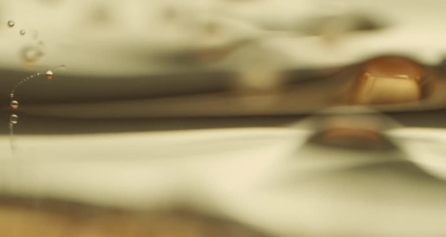 Close up of liquid droplets and the surface of fluid as it is blurred