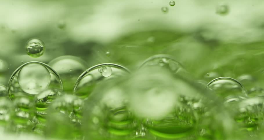 Green liquid with dense and abstract texture with slowly moving bubbles