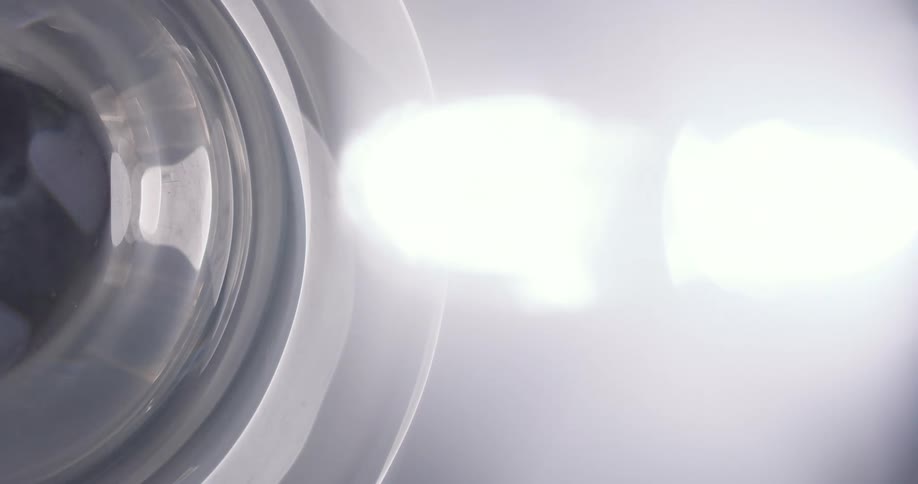 A metal wheel rotates very fast with a glaring white light emitting off of it