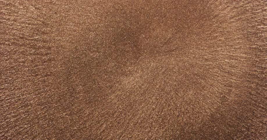 Copper bronze particles rippling in a liquid