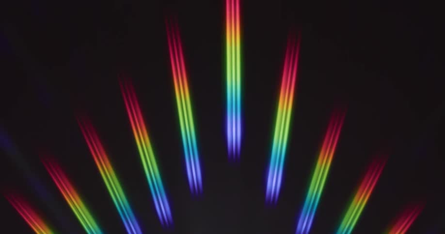 Rainbow rays of light reflect on a black surface