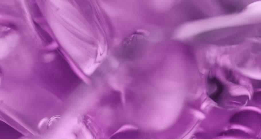 Clear purple liquid slowly flowing across in bubbles