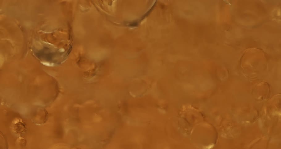 Clear soapy bubbles moving around slowly in a tank of liquid