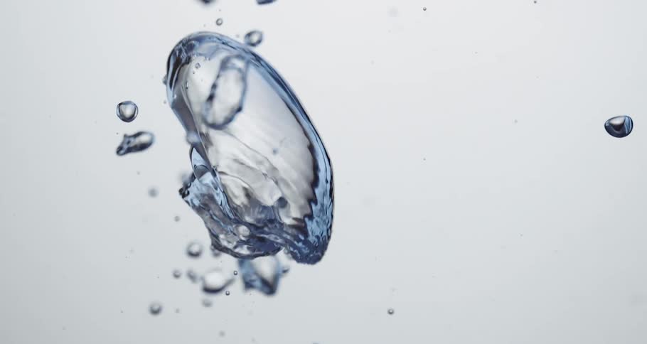 Clear liquid rippling upward weightlessly trailedby small bubbles