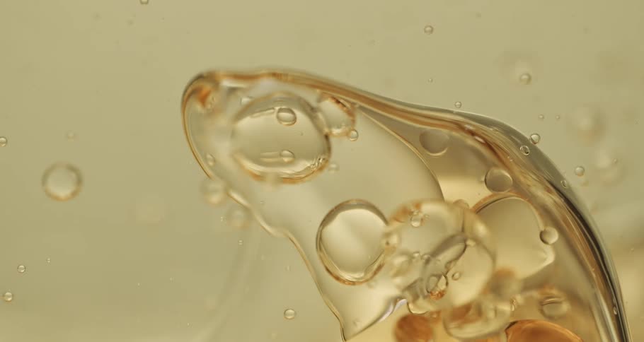 Clear liquid bubbles slowly moving and forming out of a soapy substance