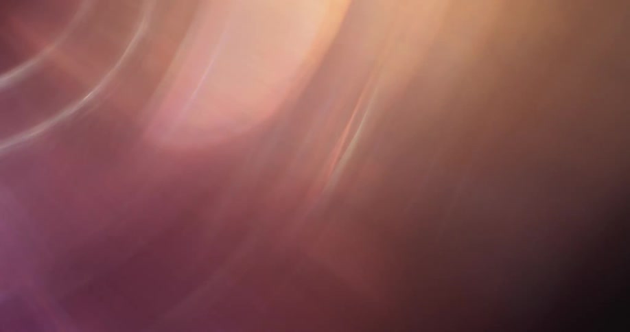 Colorful lights reflect and flare on a lens against a black background