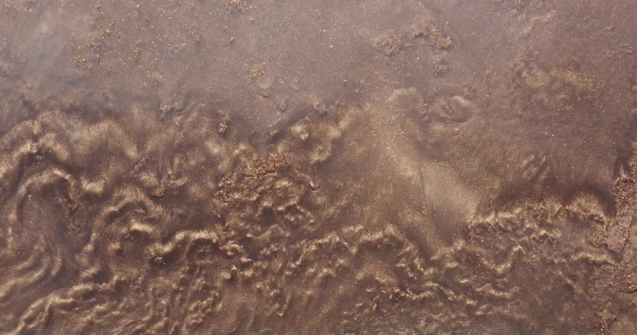 Mixture containing golden particles contains waves as it flows