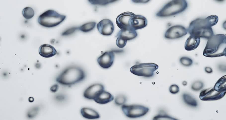 Clear blue water droplets magnified up close rise upwards