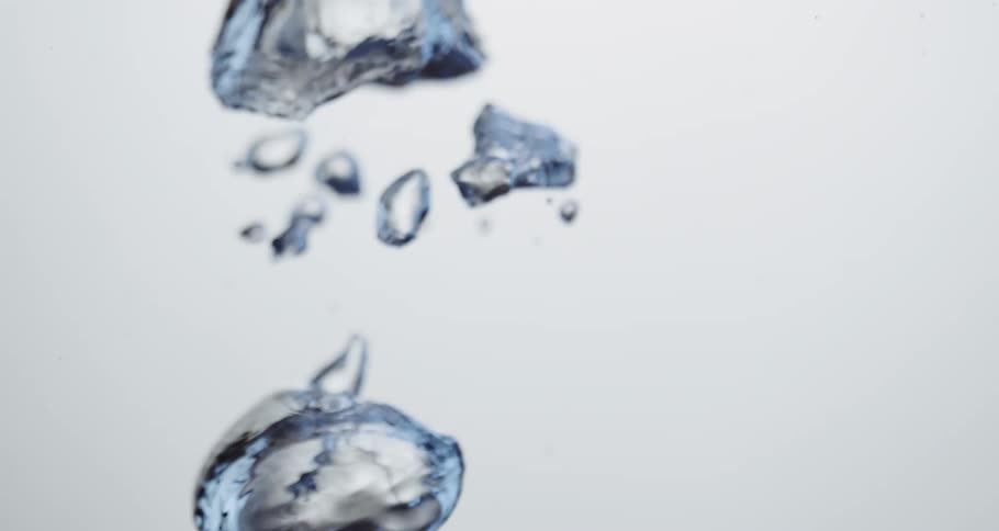 Water droplets slowly moving upward against a white canvas background
