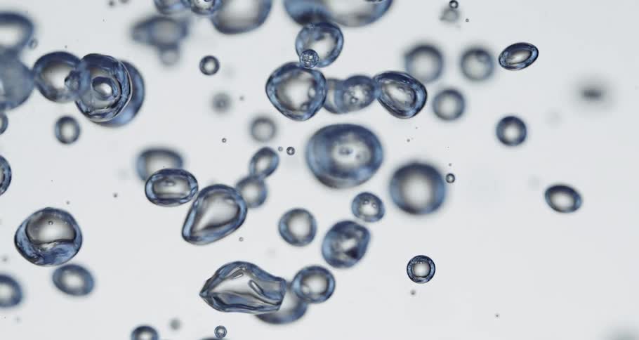Bubbles floating through fluid have blue surfaces