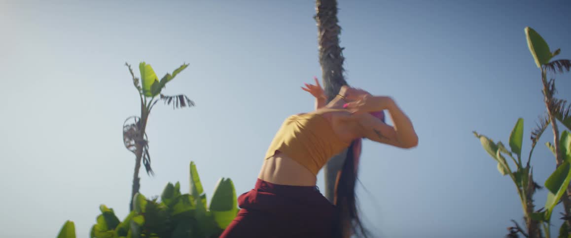 A woman dancing in nature on a sunny day