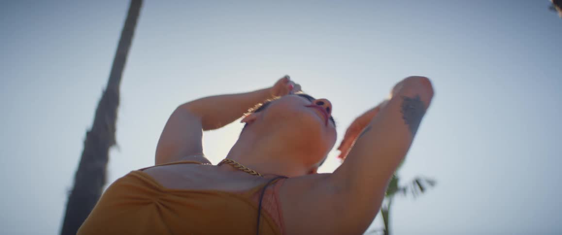 A young tattooed woman is moving her arms in tones of performance