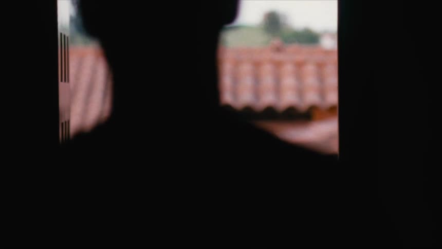 Silhouette of a man walking out of a house