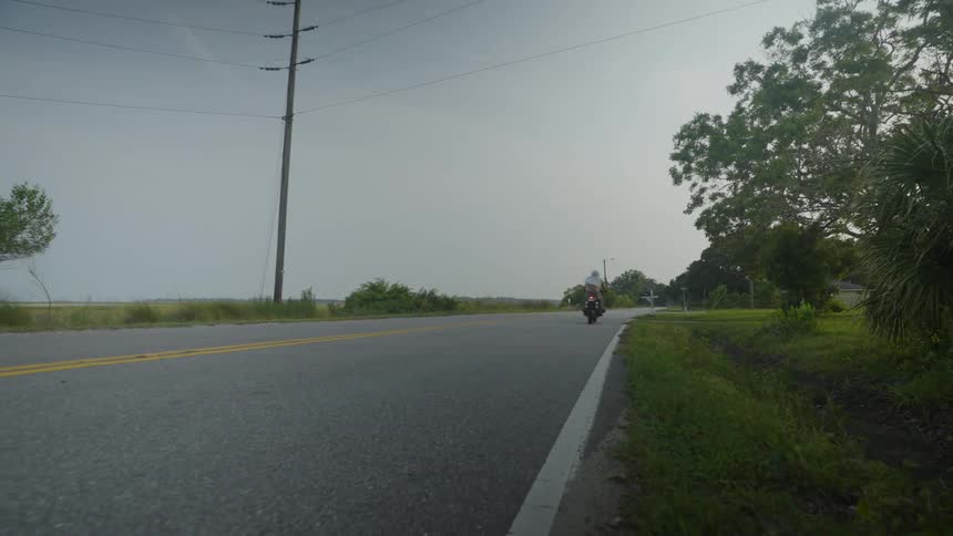 A person speeds down the street on a motorcycle