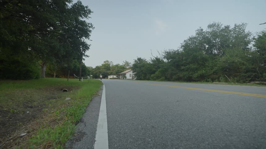 A person rides a motorcycle on a rural road at daytime