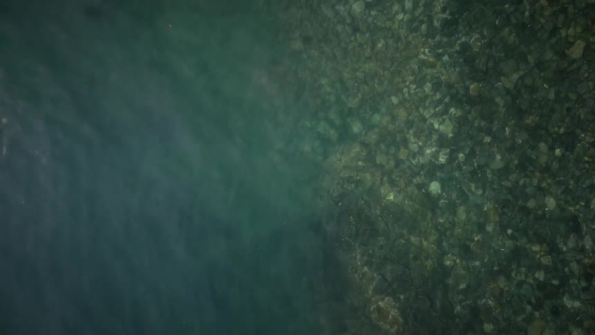 Aerial view of the turquoise blue sea with rocks