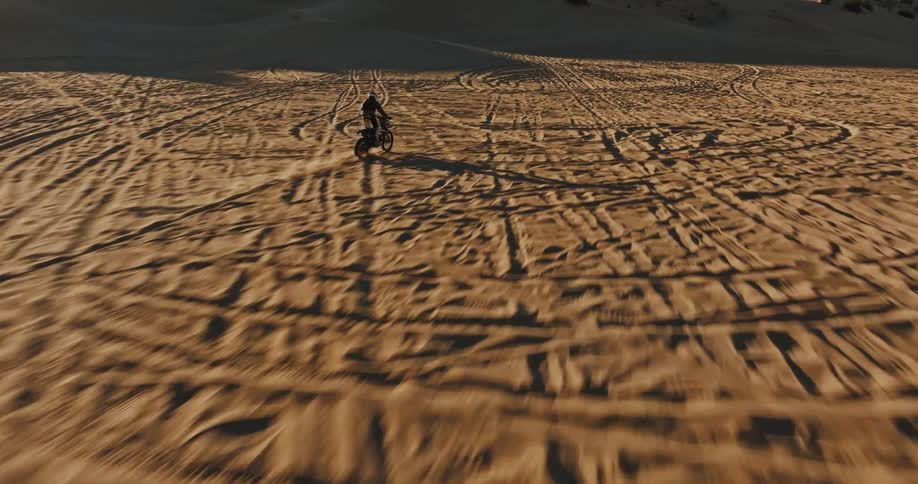 A motorbike speeding across a desert plain