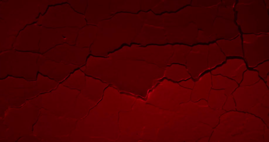 Dried red paint rippling and cracking into pieces