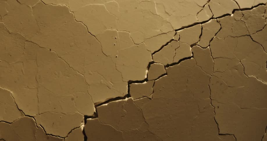 Dried brown paint rippling and cracking into pieces