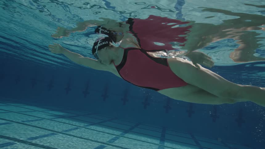 View from underwater of a person diving and swimming