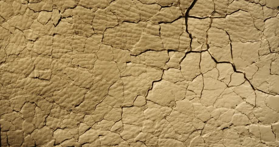 Movement breaks and cracks a textured brown surface