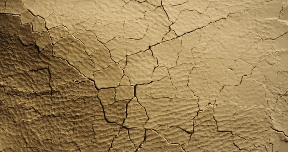 Movement breaks and cracks a textured brown surface