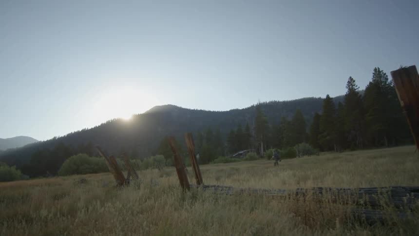 A man is hiking on the field in the distance